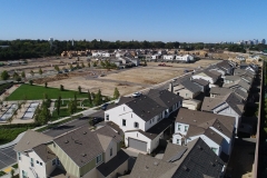 aerial view of a new development with multiple buildings and lots at various stages of construction