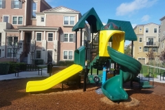 children's playground slide with residential buildings in the background