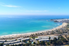 wide aerial view of ocean lined by beach and residential communities