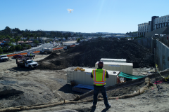 Pacific States Aerial pilot flying a drone over a stock pile at a construction site for data collection
